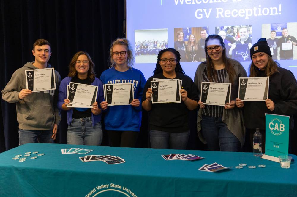 Six students showing their I am GV certificates.
